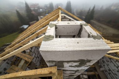 Çatı çerçeve kaba ahşap kereste kirişler ve plakalar üstten görünüm duvar içi boş köpük yalıtım bloklar kırsal manzara arka plan üzerinde yapılmış. Bina, çatı kaplama, inşaat ve yenileme kavramı.