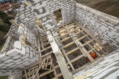 Yukarıdan gelecekteki multi depolanan yazlık enerji tasarrufu büyük beyaz içi boş köpük yalıtım blokları ve geçici ahşap iskele çerçeve görüntüleyin. İnşaat duvar, modern teknoloji kavramı.