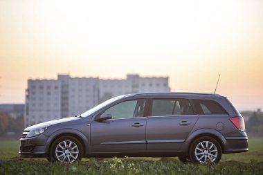 Kırsal bulanık kırsal manzara ve parlak turuncu açık gökyüzü günbatımı kopya alan arka plan, gri gümüş boş araba yan görünüm Park. Ulaşım, seyahat, Araçlar tasarım konsepti.