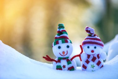 İki küçük komik oyuncak bebek kardan adam örgü şapkalı ve eşarplı açık havada açık havada açık mavi ve beyaz fotokopi arkaplanda. Mutlu yıllar ve Mutlu Noeller tebrik kartı.