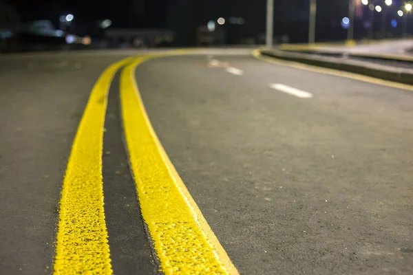 Wide bright yellow street marking sign line along modern wide smooth empty asphalt highway stretching to horizon. Speed, safety, comfortable journey and professional road building concept.