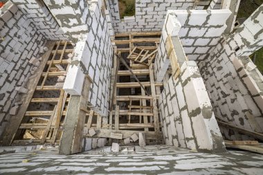 Yukarıdan gelecekteki multi depolanan yazlık enerji tasarrufu büyük beyaz içi boş köpük yalıtım blokları ve geçici ahşap iskele çerçeve görüntüleyin. İnşaat duvar, modern teknoloji kavramı.