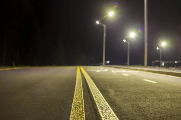 明るい白の夜記号線をマーキング アスファルト道路の街路灯で照らされた広いモダンな滑らかな空 安全性 快適な旅とプロの道建物コンセプト — ストック写真