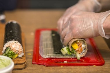 Suşi ve rulo yapma işlemi. Yakın çekim adam şef eller ev ya da mutfak masasında Restoran geleneksel Japon gıda hazırlama.