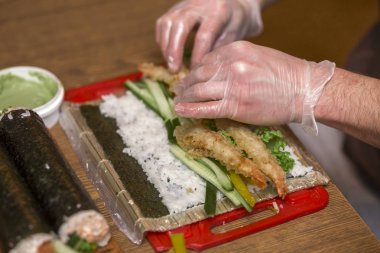 Suşi ve rulo yapma işlemi. Yakın çekim adam şef eller ev ya da mutfak masasında Restoran geleneksel Japon gıda hazırlama.