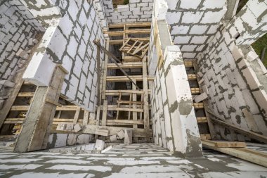 Yukarıdan gelecekteki multi depolanan yazlık enerji tasarrufu büyük beyaz içi boş köpük yalıtım blokları ve geçici ahşap iskele çerçeve görüntüleyin. İnşaat duvar, modern teknoloji kavramı.