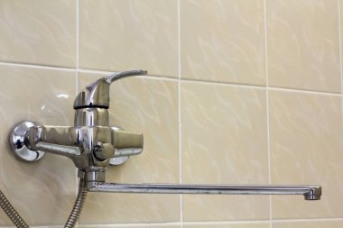 Su musluk, krom paslanmaz metal musluk duş durak Çinili duvar, mikser soğuk sıcak su bulanık banyo kopya alan arka plan üzerinde bağlı. Modern ev iç.