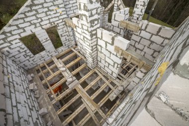 Yukarıdan gelecekteki multi depolanan yazlık enerji tasarrufu büyük beyaz içi boş köpük yalıtım blokları ve geçici ahşap iskele çerçeve görüntüleyin. İnşaat duvar, modern teknoloji kavramı.