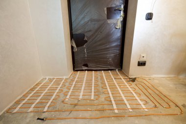 Isıtma kırmızı elektrik kablosu tel sistemi ile küçük yeni bitmemiş odada çimento katta yüklü duvarlar sıvalı. Tadilat ve inşaat, modern teknoloji, rahat sıcak ev concept.