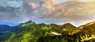 Sabah güneş yeşil vadi, orman ve uzak sisli dağlar yamalar rüzgarlı bulutlu gökyüzü altında kar ile kaplı tepeler tarafından geniş Panoraması yaktı. Güzellik, Doğa, turizm ve seyahat kavramı.
