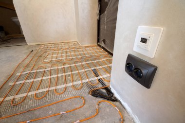 Isıtma kırmızı elektrik kablosu tel sistemi ile küçük yeni bitmemiş odada çimento katta yüklü duvarlar sıvalı. Tadilat ve inşaat, modern teknoloji, rahat sıcak ev concept.