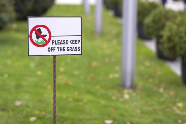 Güneşli yaz gününde yeşil çim çimen bulanık bokeh arka plan çim tabelada kapalı unutmayın. Şehir yaşam tarzı ve doğa koruma kavramı.