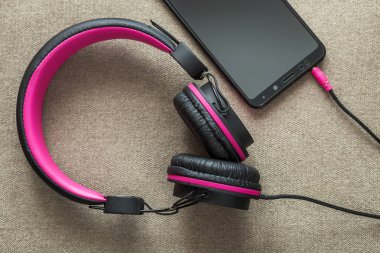 Cep telefonu hafif kumaş tam kopyaya uzay arka plan üzerinde izole kulaklık bağlı. Modern teknoloji, son moda eğlence, gadget tasarım ve aksesuarları kavramı.