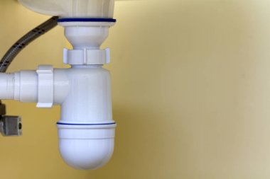 Yeni modern seramik beyaz lavabo lavabo bağlantı kanalizasyon için ayrıntı görünümünü kopya alan arka plan açık bej seramik karo üzerinde. Profesyonel tesisat ve montaj kavramı.