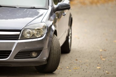 Gri parlak araba bulanık bokeh arka plan asfalt yolda sessiz alanı'nda parlak güneşli gün Park. Ulaşım ve Park kavramı.