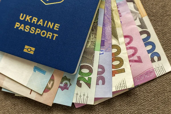 Ukrainian passport and money, Ukrainian hryvna banknotes bills on copy space background, top view. Traveling and  finance problems concept.