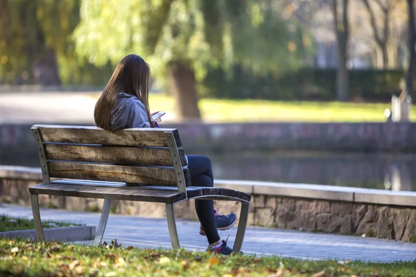 Rückansicht Des Jungen Mädchens Mit Langen Haaren Sitzt Auf Holzbank — Stockfoto