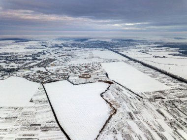 Dramatik bulutlu gökyüzü arka plan üzerinde kış sabahı üstten görünüm boş karlı alanları. Hava dron fotoğraf kavramı.