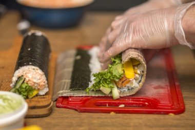 Suşi ve rulo yapma işlemi. Yakın çekim adam şef eller ev ya da mutfak masasında Restoran geleneksel Japon gıda hazırlama.