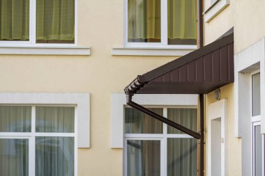 Köşe giriş çelik cilt payı yağmur sistemi ile yukarıda yeni bir çatı inşa. Dayanıklılık, profesyonel inşaat, drenaj boruları kurulum ve bağlantı kavramı.