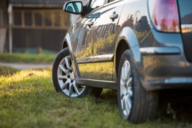 Yeşil çimenlerin üzerinde bulanık güneşli yaz kırsal arka plan üzerinde yeni parlak gri araba park.