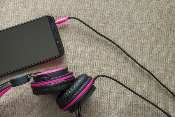 Συνδεδεμένα Ακουστικά Στο Κινητό Τηλέφωνο Που Απομονώνονται Ελαφρύ Ύφασμα Απλό — Φωτογραφία Αρχείου