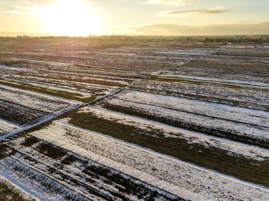 Üstten görünüm boş karlı alanların peyzaj, karanlık ufuk ve parlak gökyüzü güneşli kış gününde yamalı. Hava dron fotoğraf kavramı.