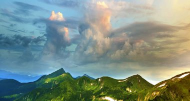 Sabah güneş yeşil vadi, orman ve uzak sisli dağlar yamalar rüzgarlı bulutlu gökyüzü altında kar ile kaplı tepeler tarafından geniş Panoraması yaktı. Güzellik, Doğa, turizm ve seyahat kavramı.