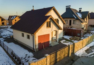 Modern banliyö bölgesi içinde güneşli kış gününde çit yarda üzerinde havadan görünümü yeni konut ev yazlık ve shingle çatı ile ekli garajı. Hayalinizdeki evi mükemmel yatırım.