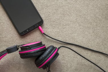 Cep telefonu hafif kumaş tam kopyaya uzay arka plan üzerinde izole kulaklık bağlı. Modern teknoloji, son moda eğlence, gadget tasarım ve aksesuarları kavramı.