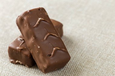 İki izole izole koyu kahverengi çikolata şeker çubukları ışık tuval bezi kopya alan arka plan üzerinde snickers. Lezzetli yemekler, besleyici, Aperatif kavramı.