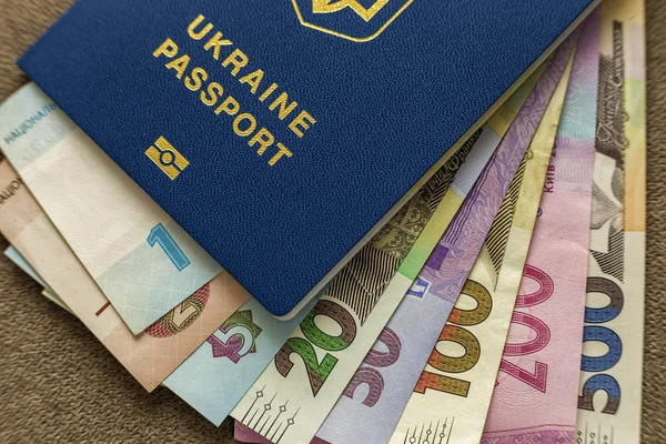 Ukrainian passport and money, Ukrainian hryvna banknotes bills on copy space background, top view. Traveling and  finance problems concept.