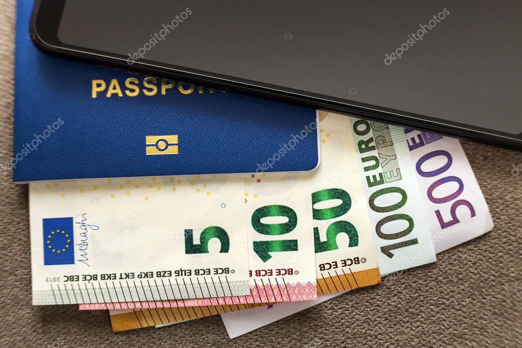 Modern black cellphone, Euro money banknotes bills and travel passport on copy space background. Travelling light, comfortable journey concept.