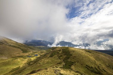 Mavi gökyüzü ile beyaz bulutlar üzerinde yeşil dağların panoramik parlak güneşli gün uzay arka plan kopyalayın. Turizm ve seyahat kavramı.