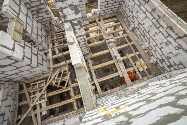 Yukarıdan gelecekteki multi depolanan yazlık enerji tasarrufu büyük beyaz içi boş köpük yalıtım blokları ve geçici ahşap iskele çerçeve görüntüleyin. İnşaat duvar, modern teknoloji kavramı.