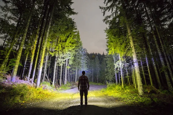 Widok człowieka z głowy latarka stojący z tyłu na terenie lasu — Zdjęcie stockowe