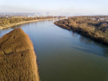 Hava üstten görünüm, sessiz nehir su ve kuru ot, güneşli mavi gökyüzü altında puslu ufuk ile ada kırsal Panoraması. Uçak fotoğraf.