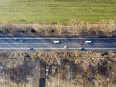 Arabalar, ağaçlar ve yeşil f hareketli düz yolda havadan görünümü