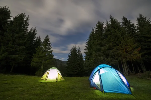Jasny księżyc duża w ciemno niebieski pochmurnego nieba nad dwa turystyczny namioty o — Zdjęcie stockowe