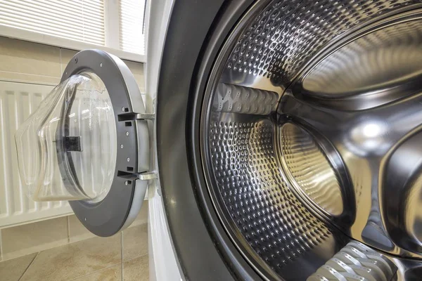 Крупный план современного интерьера стиральной машины с открытой какашкой — стоковое фото