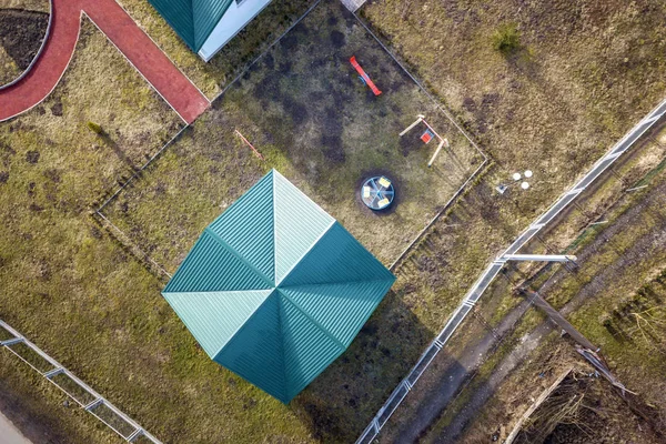 Vue aérienne du toit en bardeaux de la maternelle ou du bâtiment scolaire moderne sur une aire de jeux colorée en arrière-cour ensoleillée , — Photo