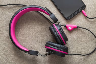 Cep telefonu üzerinde hafif kumaş düz co izole kulaklık bağlı