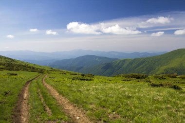 Odunsu dağlar r için önde gelen yeşil çimenli tepe üzerinde kir araba parça