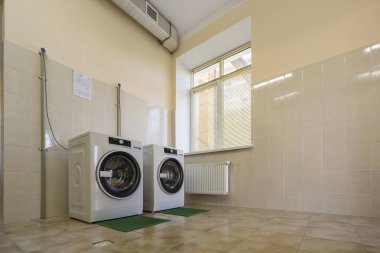 Temiz açık Karo banyo veya havalandırma sistemi ile çamaşır odasında kauçuk yalıtım paspaslar üzerinde modern yeni endüstriyel çamaşır makineleri.