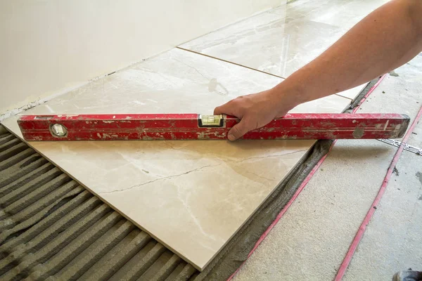 Крупный план рычага на керамической плитке на цементном полу. Тилес инстал — стоковое фото