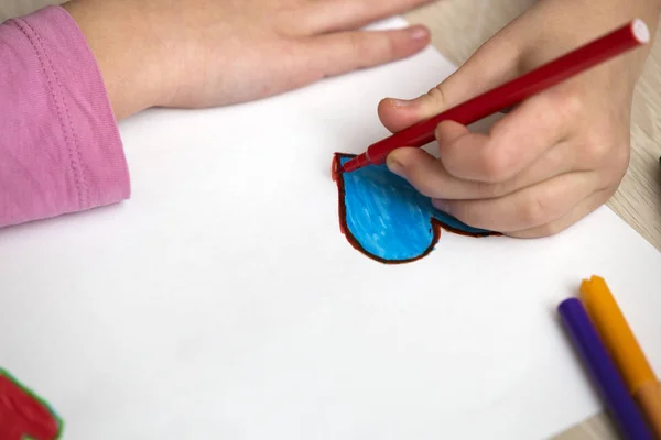 Dziecko dziewczynka na ręce rysunek z sercem kredki ołówki kolorowe — Zdjęcie stockowe