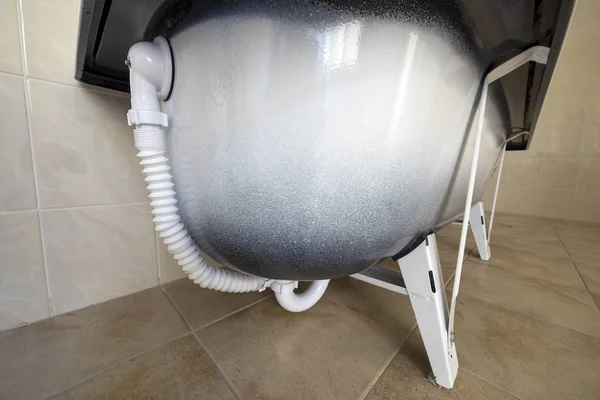 Blick von unten auf neue Keramik-Badewanne auf helle Badezimmerfliesen — Stockfoto
