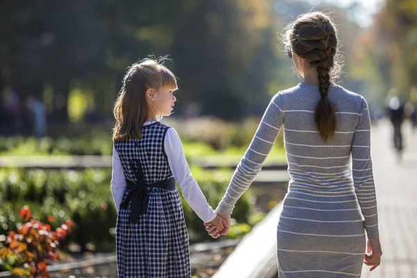 Zadní pohled na dítě dívka a matky v šatech, držící pohromadě h — Stock fotografie