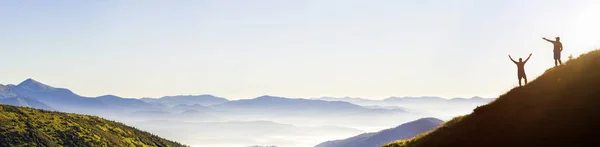 Pequeñas siluetas oscuras de los viajeros turísticos en escarpada montaña sl — Foto de Stock