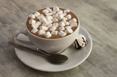 Açık renkli, üstten görünüm üzerinde porselen tabakta marshmallow ile kahve bir fincan bileşimi.